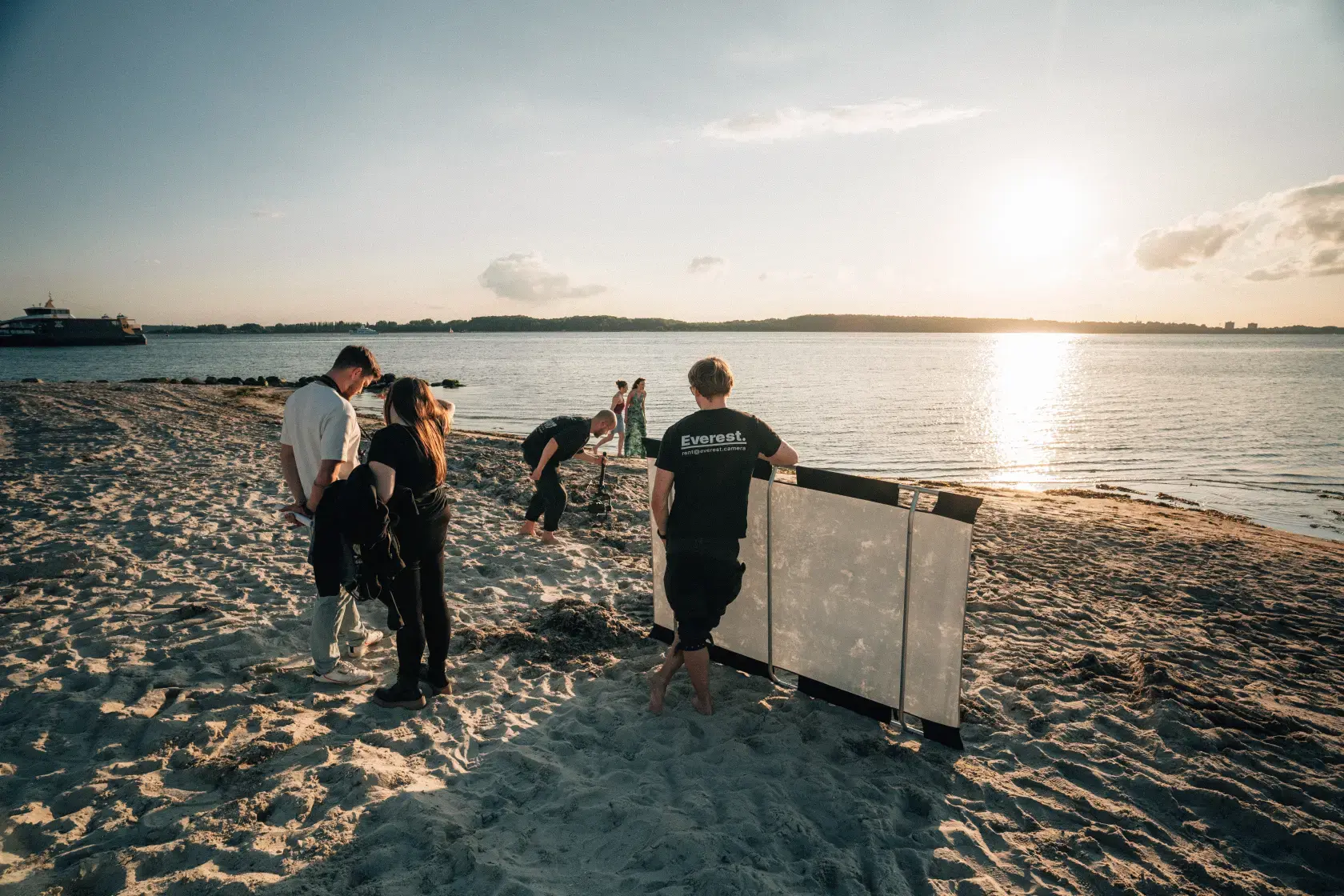 Filmteam am Strand bei untergehender Sonne bei Dreh für professionellen Content aus Kiel
