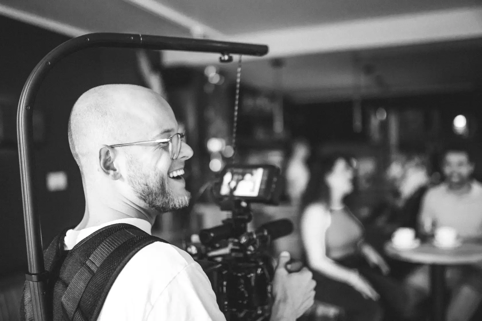 Kameramann lacht sein Team auf Videoproduktion an - Professioneller Werbedreh