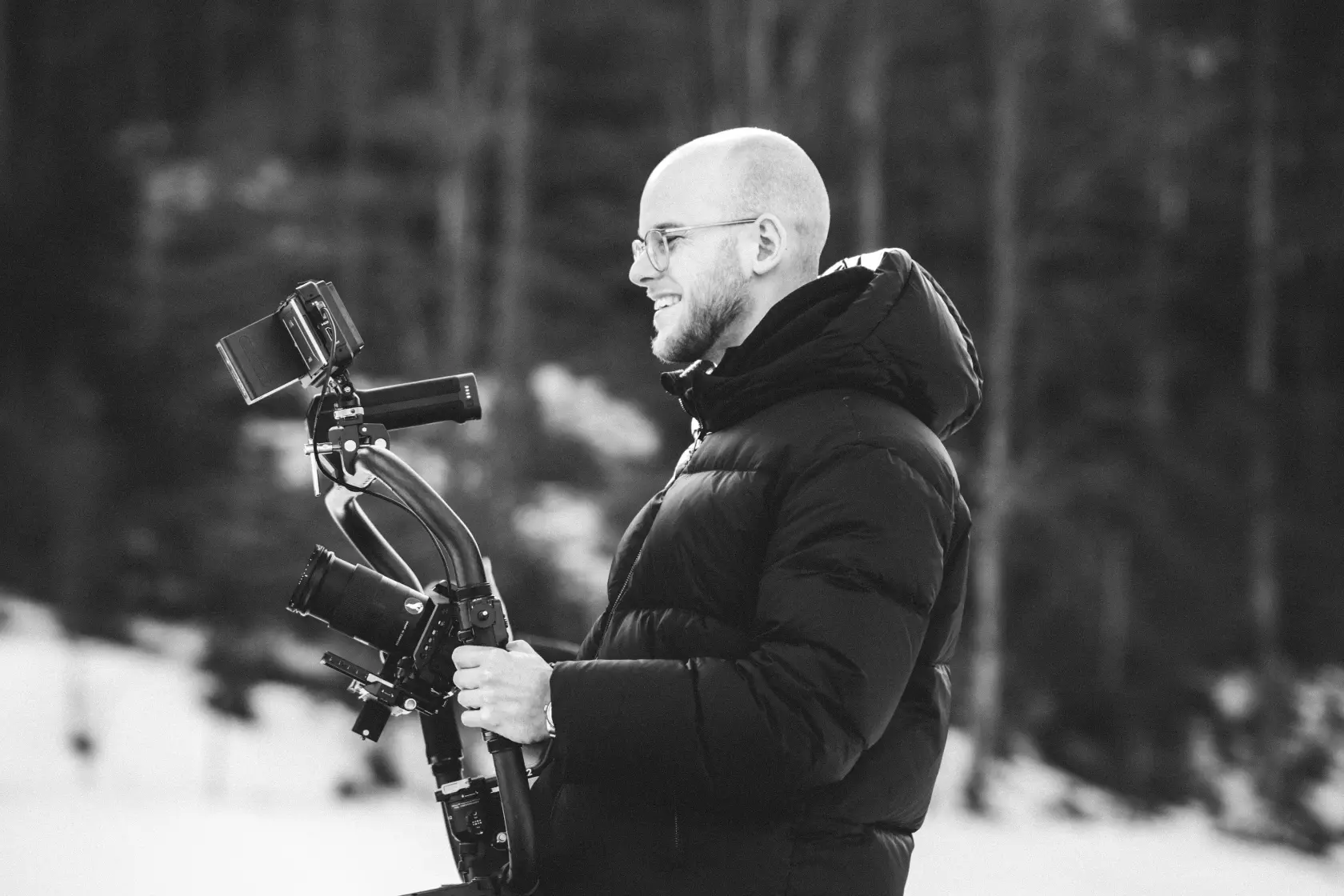 Kameramann steht in Tiefschnee mit professioneller Kameraausrüstung – Winterfilmproduktion