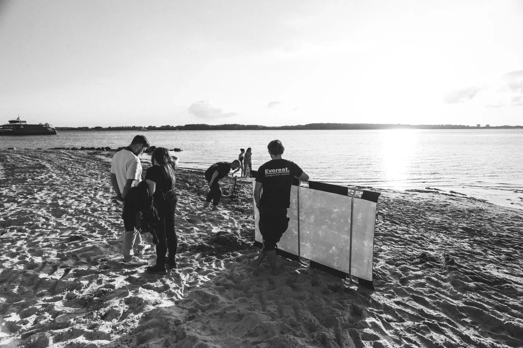 Filmcrew von MOCANOX steht am Strand in Kiel beim Sonnenuntergang