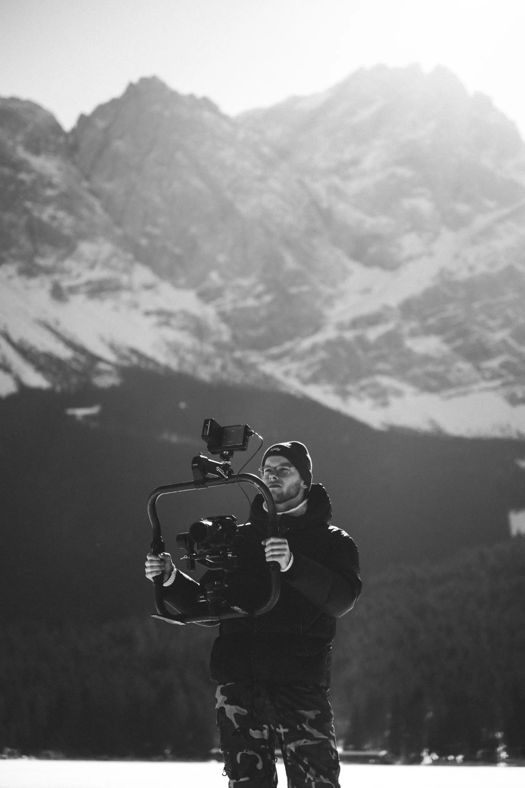 Kameramann Levin mit hochwertiger Videoausrüstung vor Berglandschaft